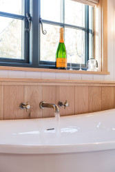 Bath running with bottle of champagne on windowsill