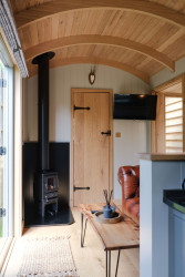 Sitting area with log burner in shepherds hut