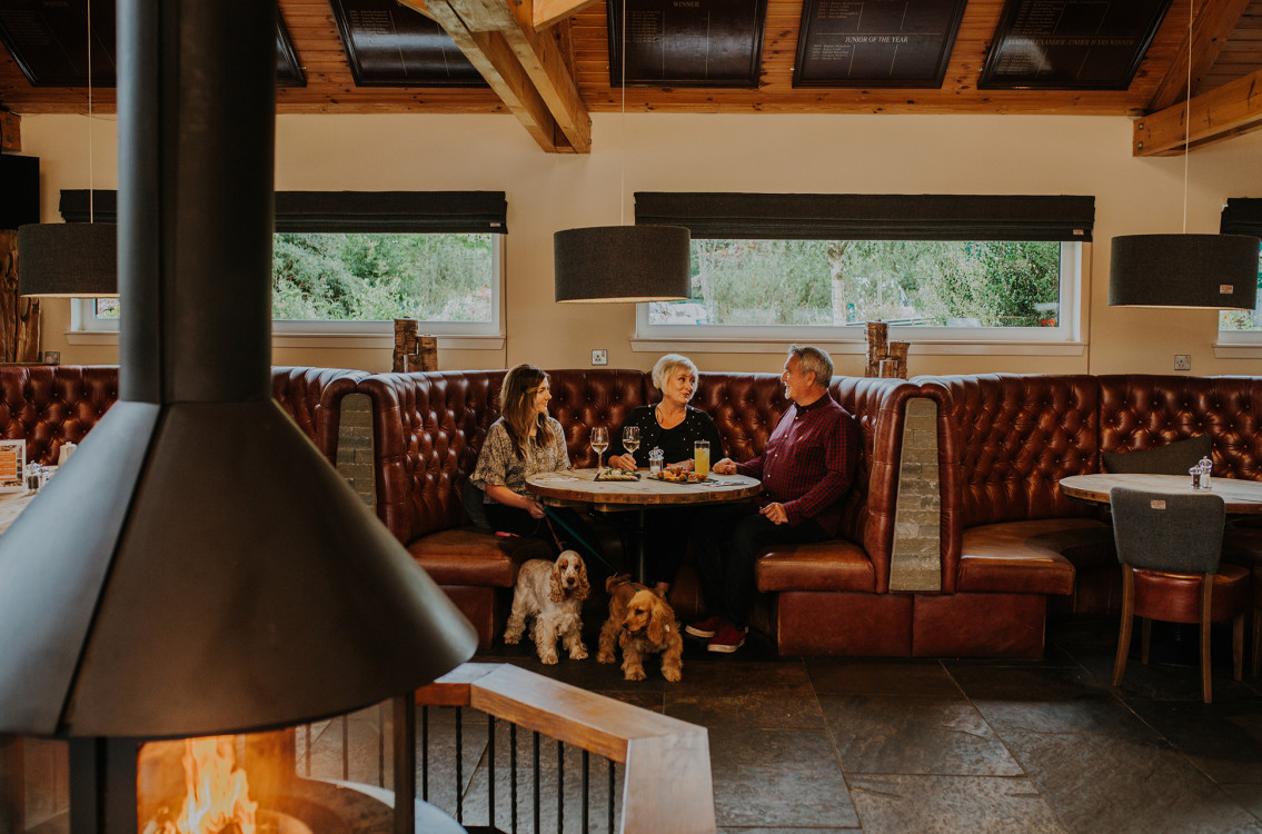 3 people eating meal in bar area with log burner