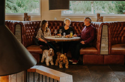 3 people eating meal in bar area with log burner