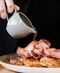 Maple syrup pouring over bacon and pancakes