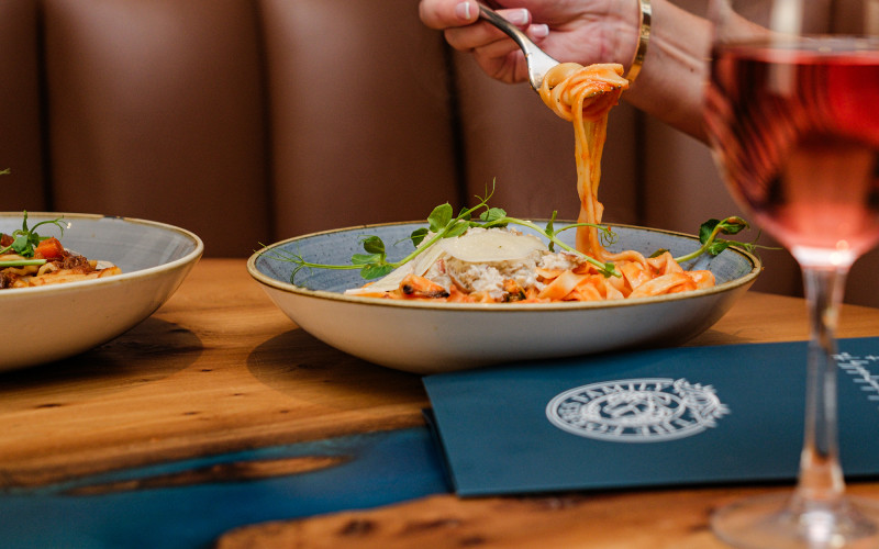 Person eating tomato pasta