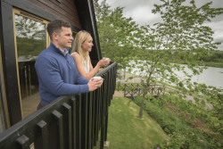 Guests on balcony of waterside lodge