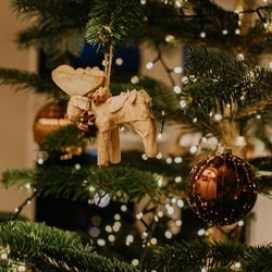 Christmas tree decorated with a wooden moose ornament and a shiny bronze bauble
