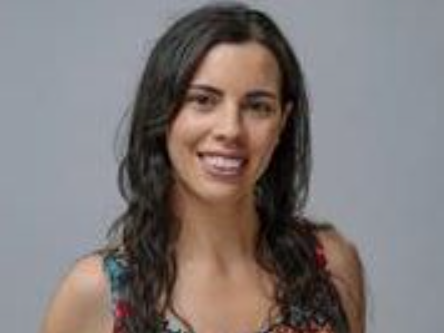 Woman with long dark hair smiling at the camera