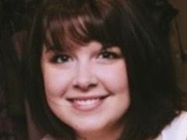 Woman with dark shoulder-length hair smiling at the camera