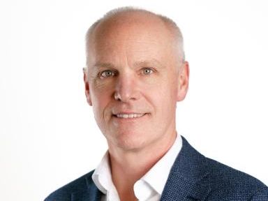 Portrait of a middle-aged man with short gray hair, wearing a blue blazer and white shirt.
