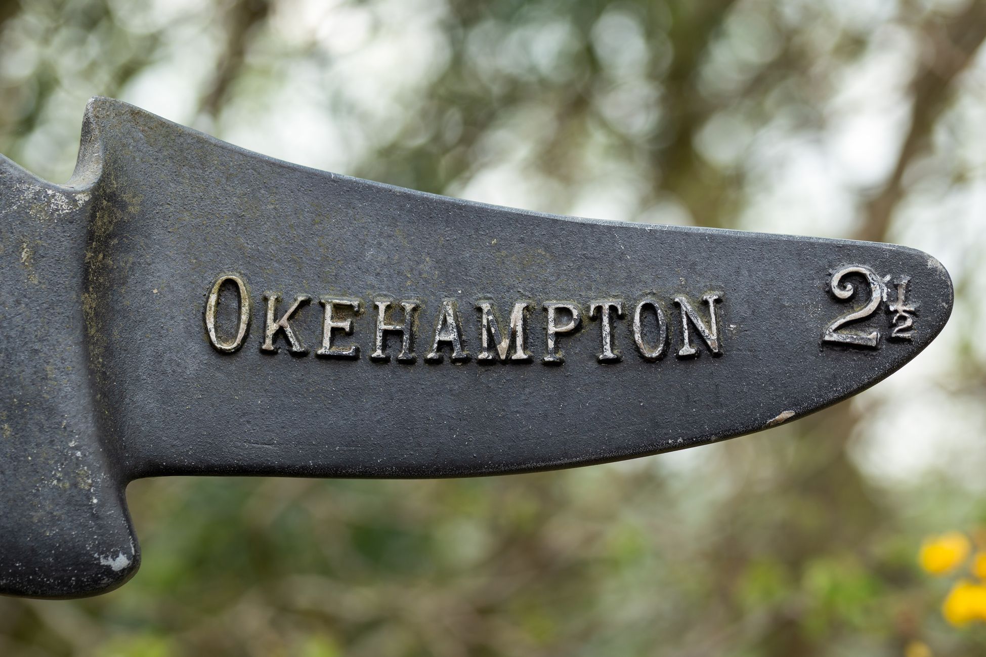 Close-up of a metal sign pointing toward 