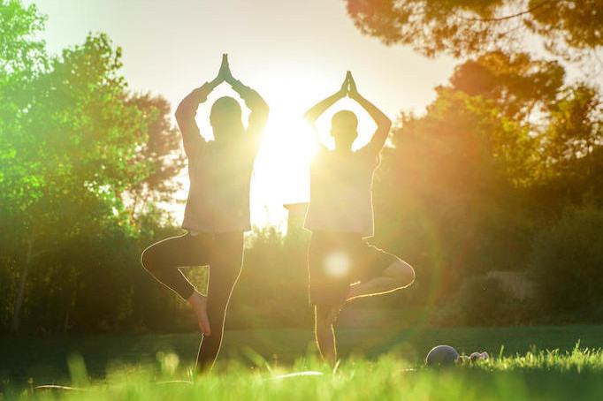 2 people doing yoga outside