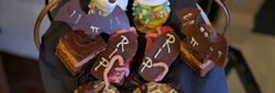 Assorted Halloween-themed desserts including ghost-shaped pastries, chocolate bats, gravestone cookies, and spider-topped biscuits.