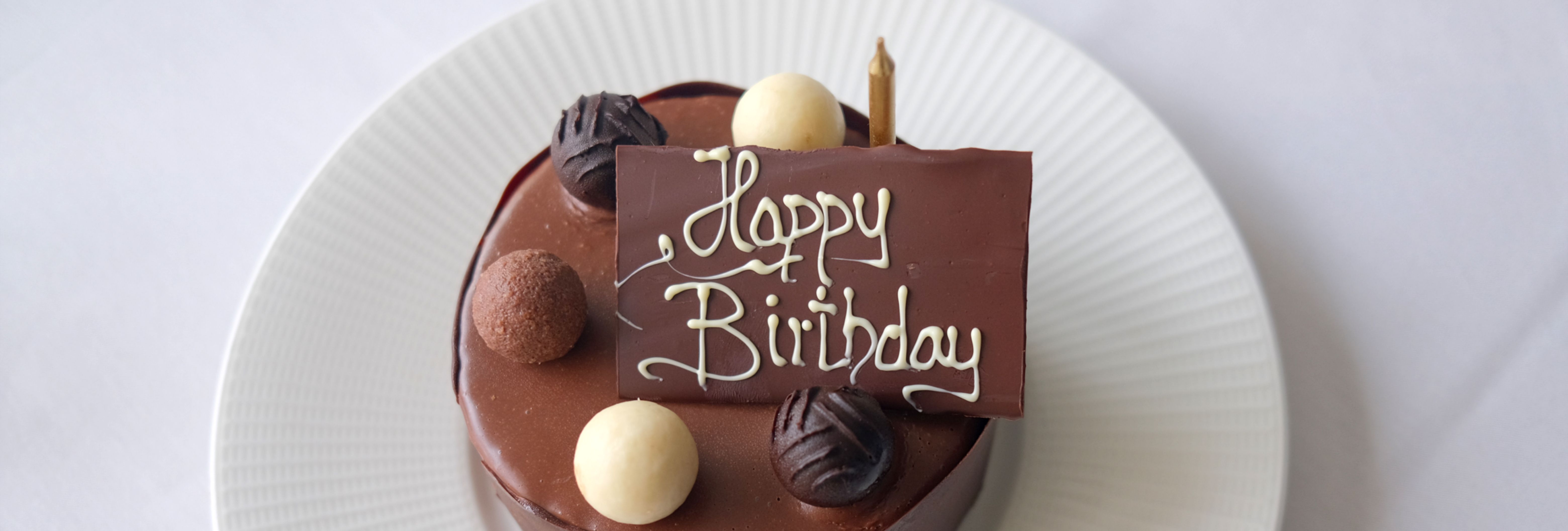 Chocolate birthday cake with assorted truffles and a 'Happy Birthday' chocolate plaque on top