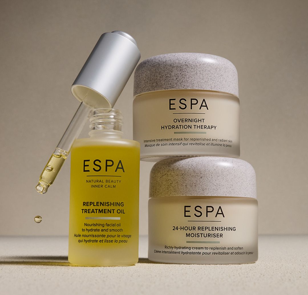 ESPA skincare products including Replenishing Treatment Oil with dropper and two moisturiser jars on a neutral background.