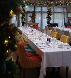 Elegant dining table with colorful chairs set for a formal meal in a decorated room.