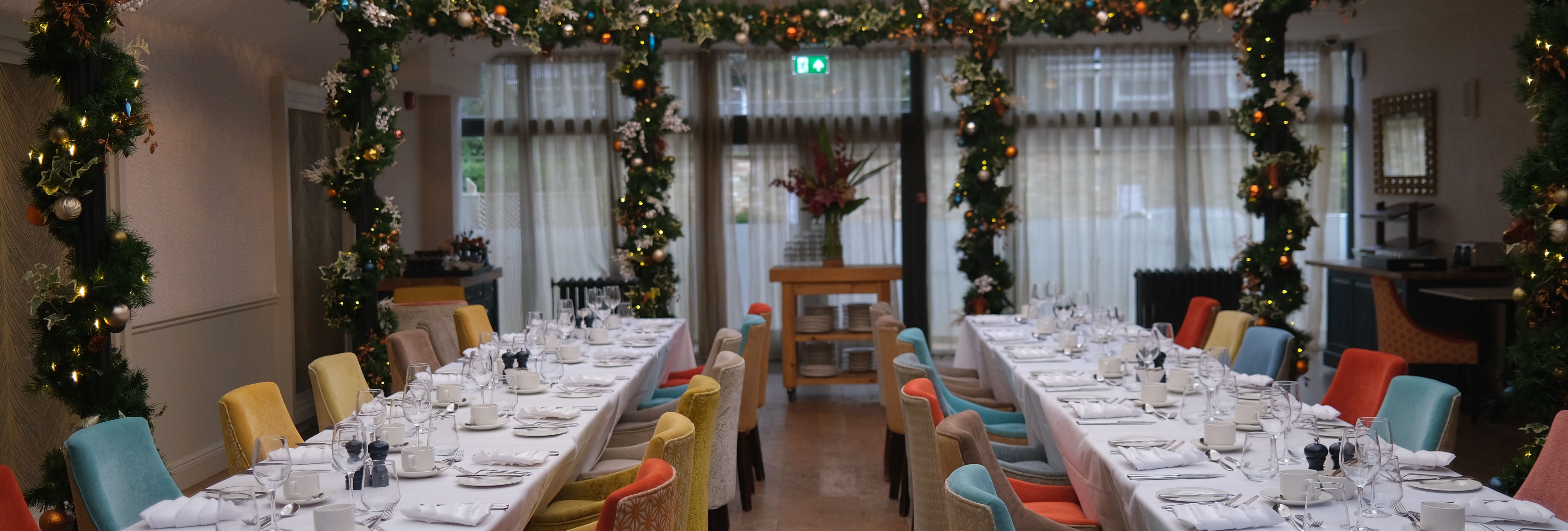 Elegant atrium dining area decorated with garlands and set for a festive meal