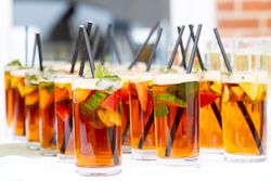 Glasses of Pimm's cocktail with fruit and mint on a table