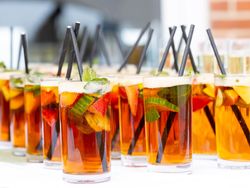 Glasses of Pimm's cocktail with fruit and mint on a table