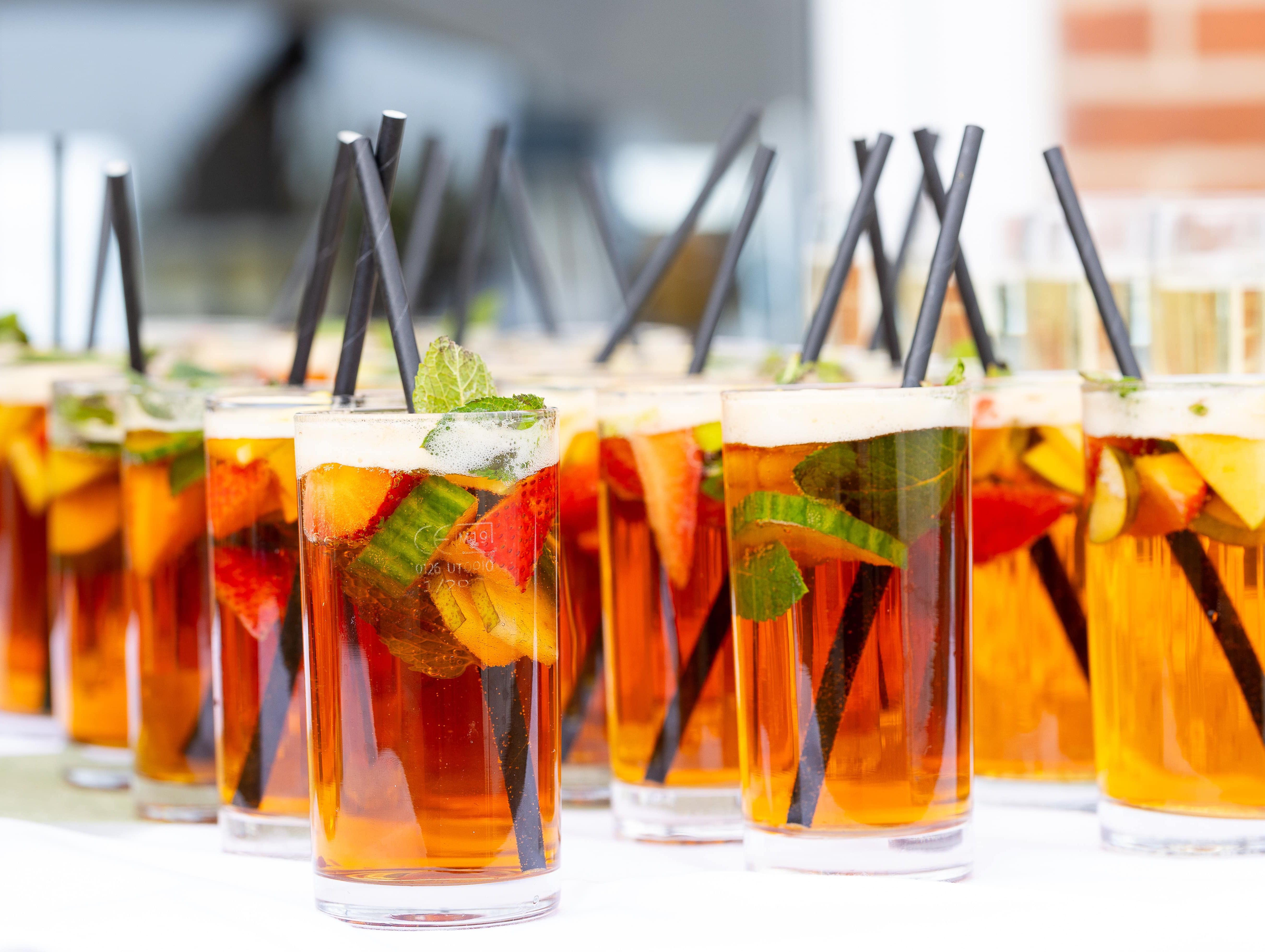 Glasses of Pimm's cocktail with fruit and mint on a table