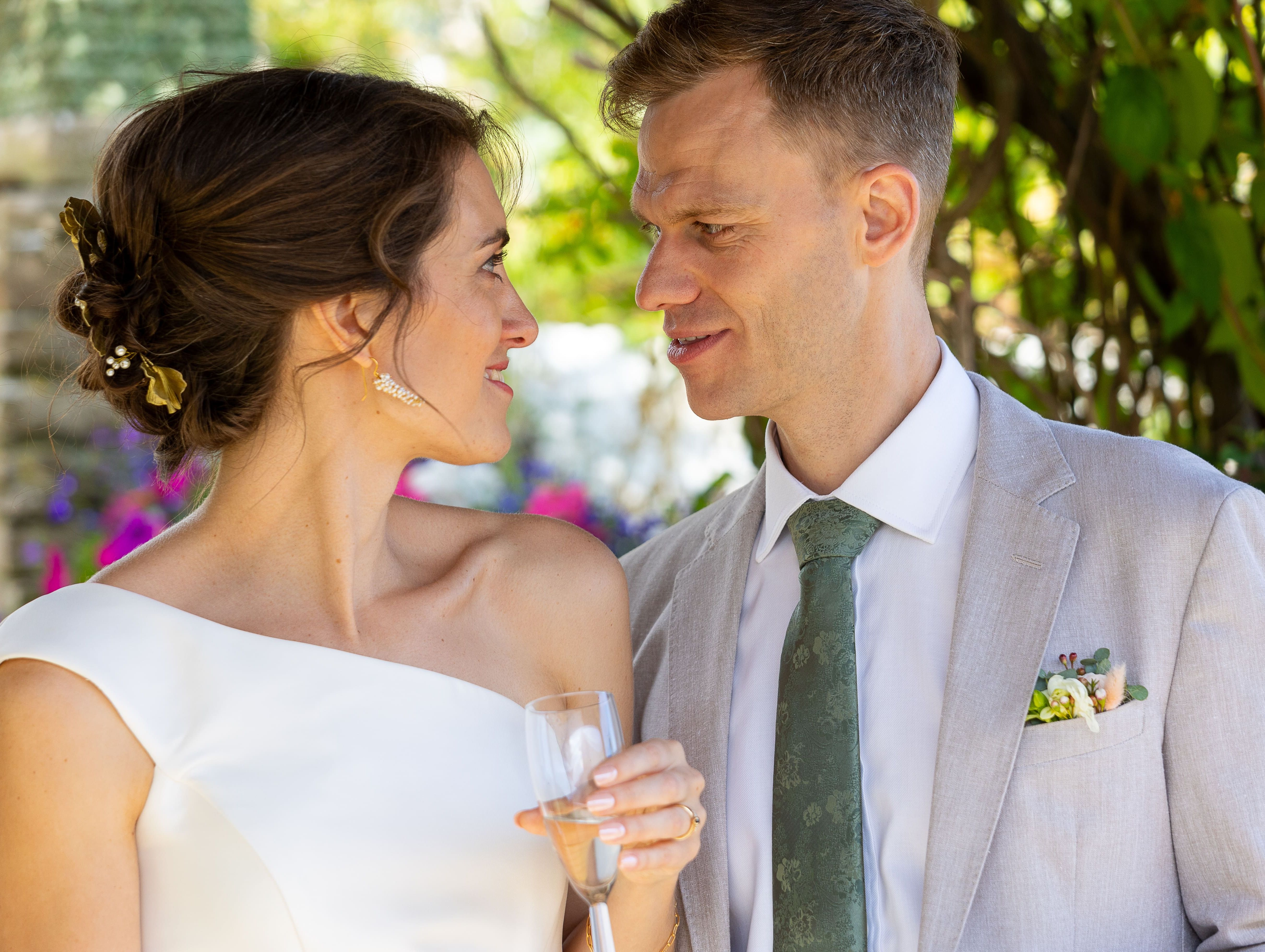 Bride and groom gazing at each other outdoors on their wedding day.
