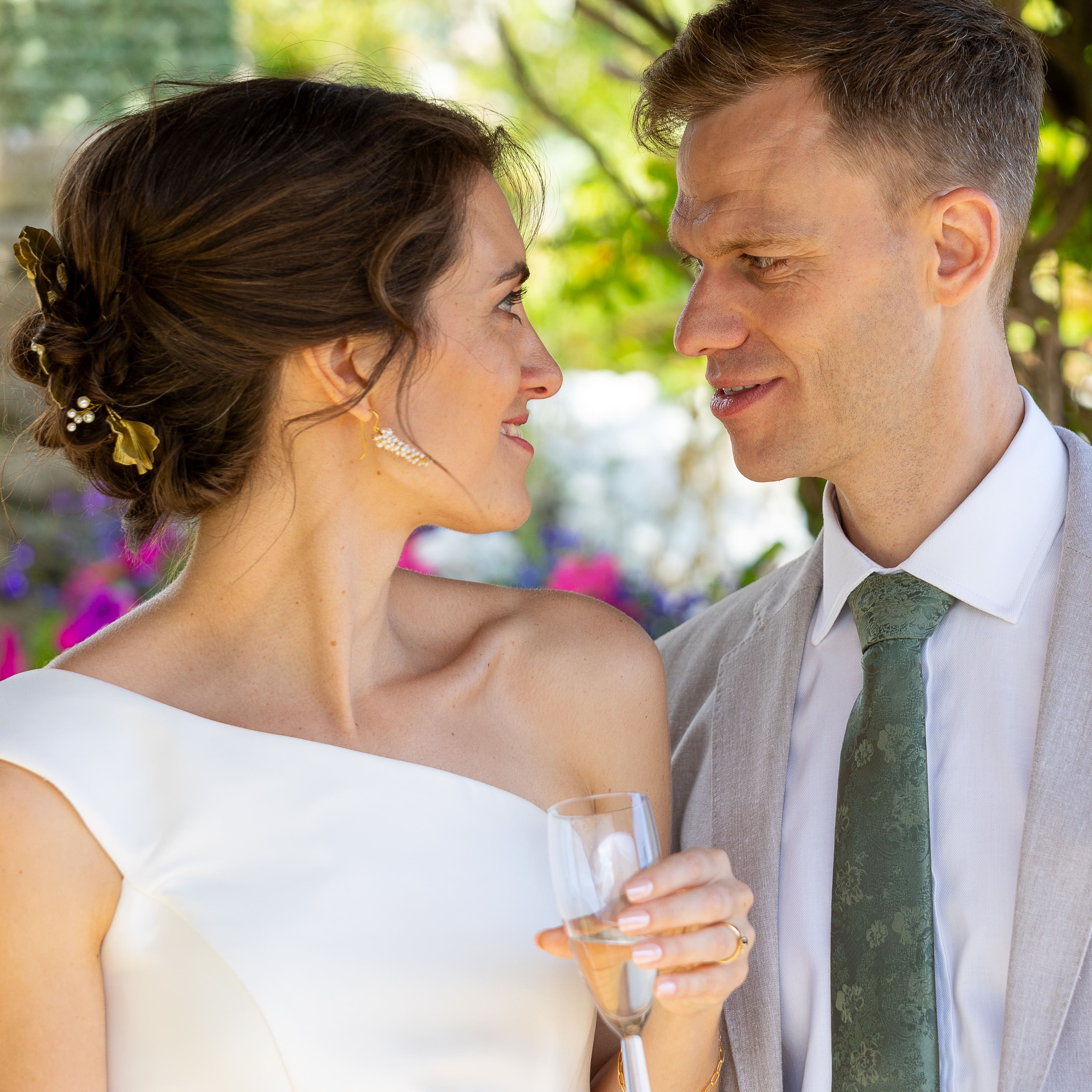 Bride and groom gazing at each other outdoors on their wedding day.
