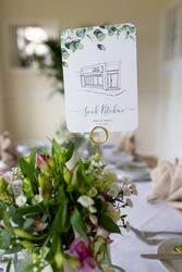 Table centerpiece with flowers and a card displaying 'Souk Kitchen' beside plates and cutlery