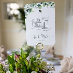 Table centerpiece with flowers and a card displaying 'Souk Kitchen' beside plates and cutlery