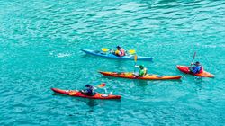 Four people kayaking on bright blue water