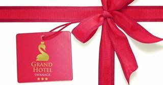 Red ribbon tied in a bow with a Grand Hotel Swanage tag and the words Gift Vouchers