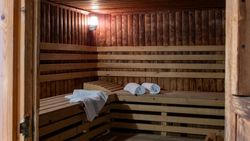 Interior of a wooden sauna with benches and neatly placed towels.