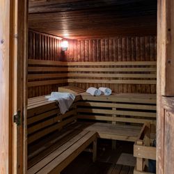 Interior of a wooden sauna with benches and neatly placed towels.
