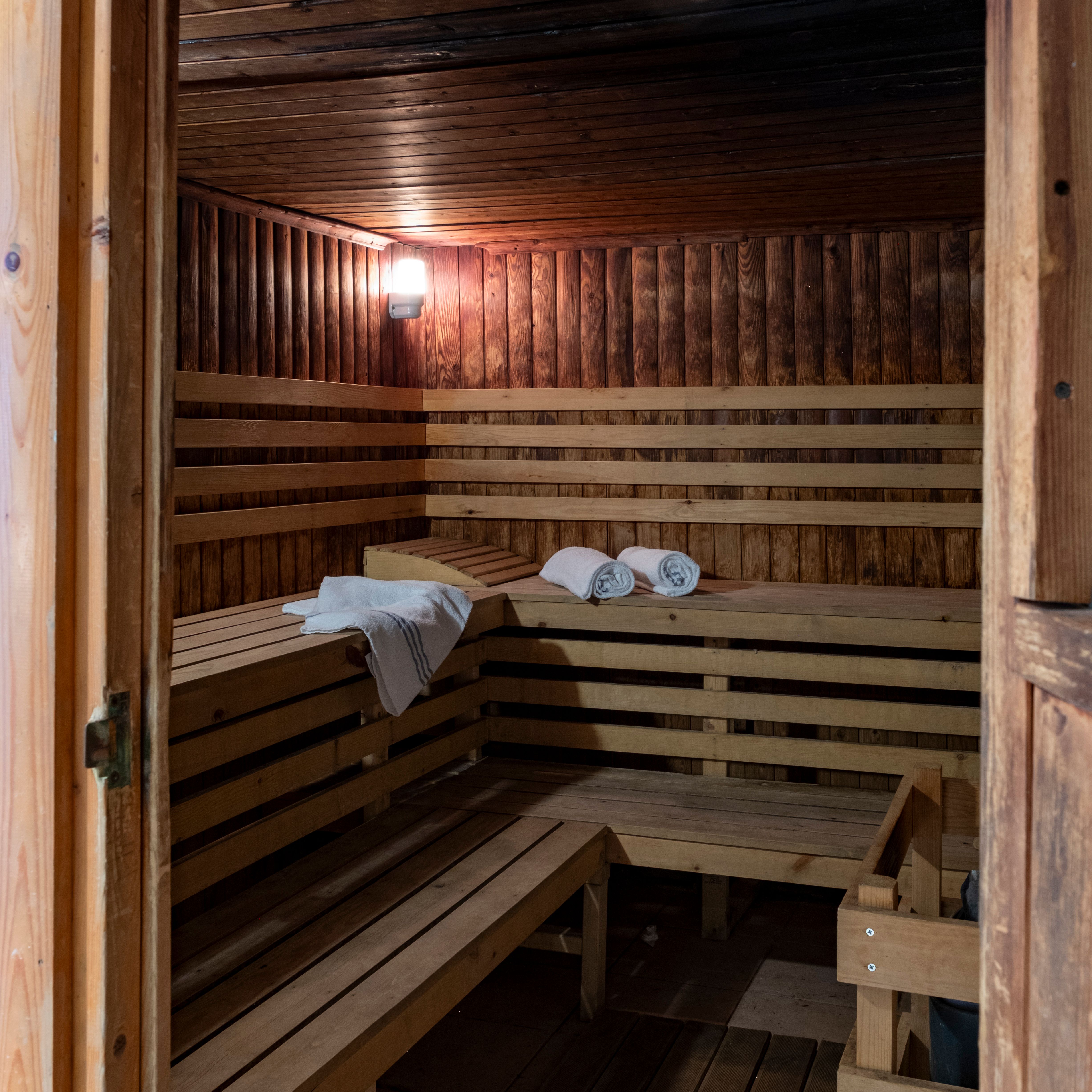 Interior of a wooden sauna with benches and neatly placed towels.