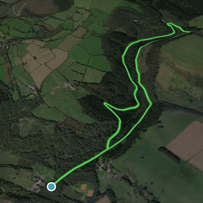 A satellite map showing a highlighted walking or biking trail through fields and wooded areas.