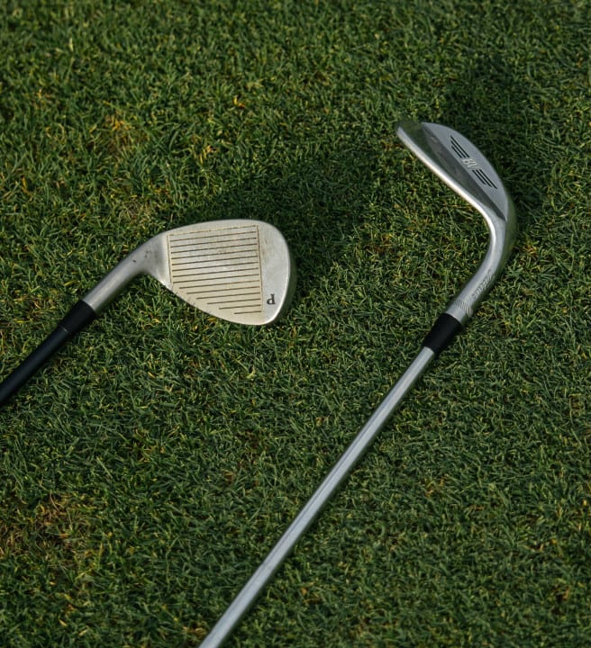 Two golf clubs lying on grass