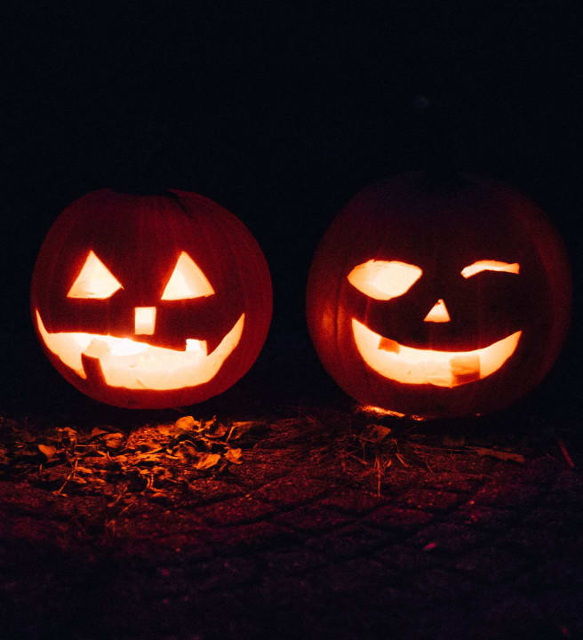Two pumpkins with faces carved into them