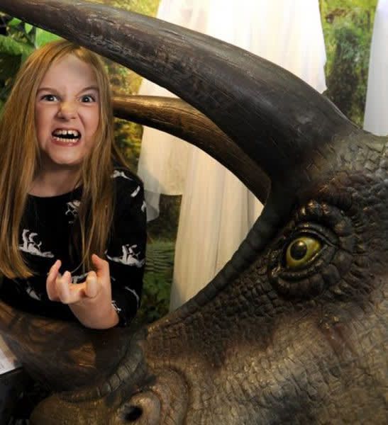 Child next to a life sized dinosaur