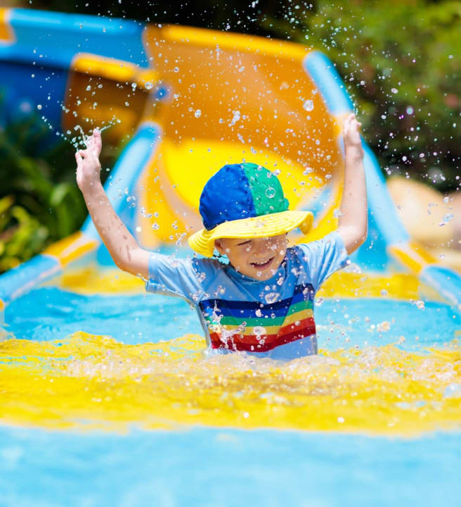 A child coming down a water slide