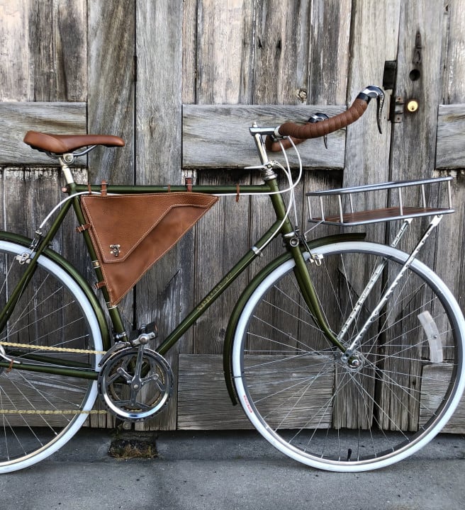 A vintage bicycle leaning against a wooden building