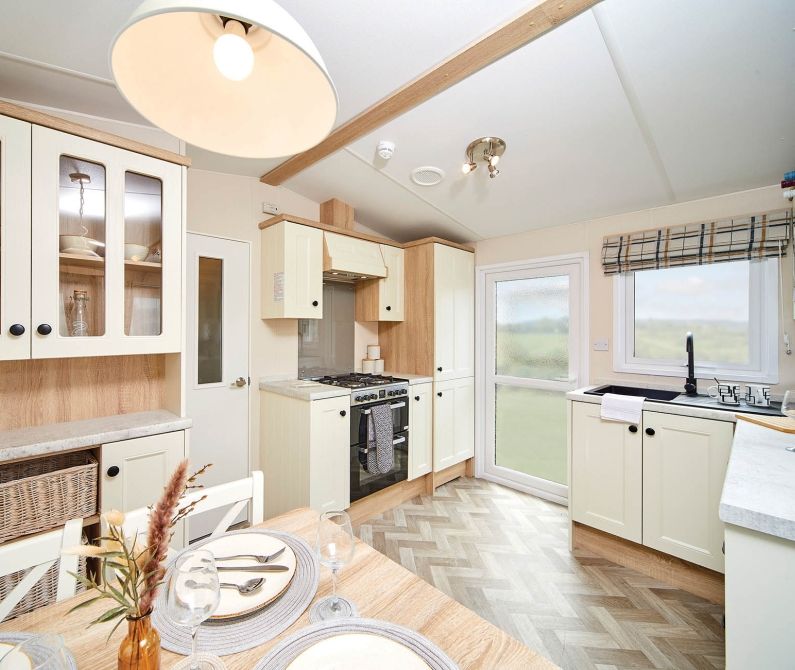 Light, classic kitchen with cream cabinets, wooden worktops and dining table
