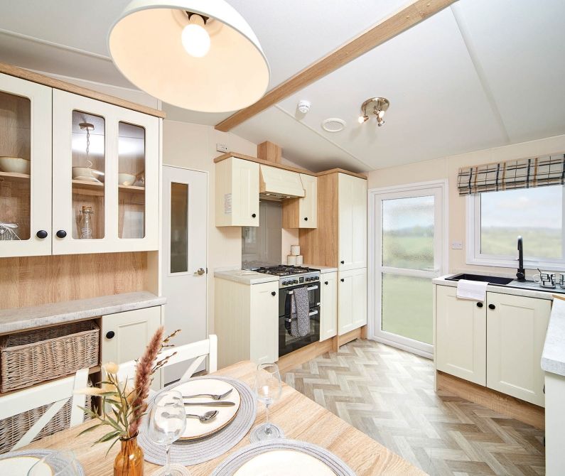 Light, classic kitchen with cream cabinets, wooden worktops and dining table