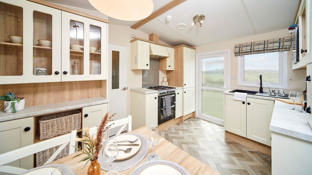 Light, classic kitchen with cream cabinets, wooden worktops and dining table