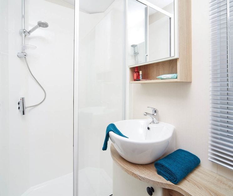 Modern shower room with glass enclosure, basin sink and mirrored cabinet