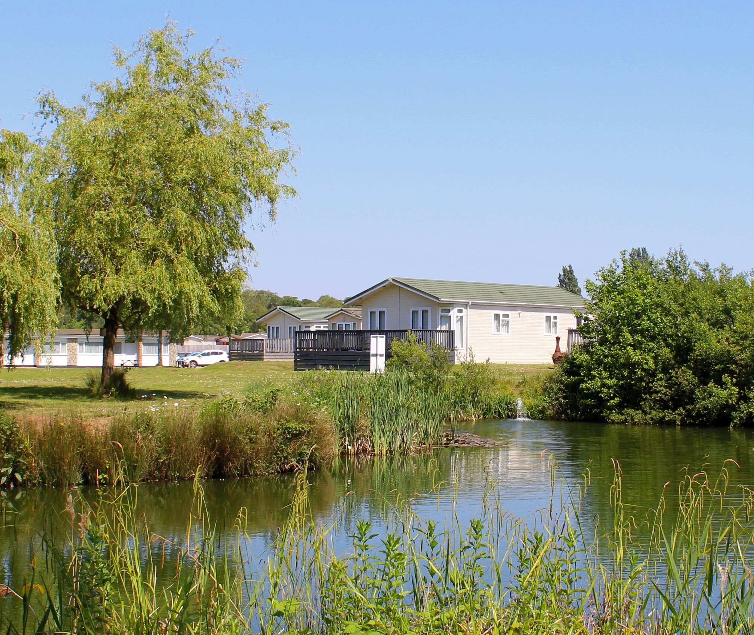 Holiday lodges overlooking a fishing lake at Hazelwood Holiday Park, Devon