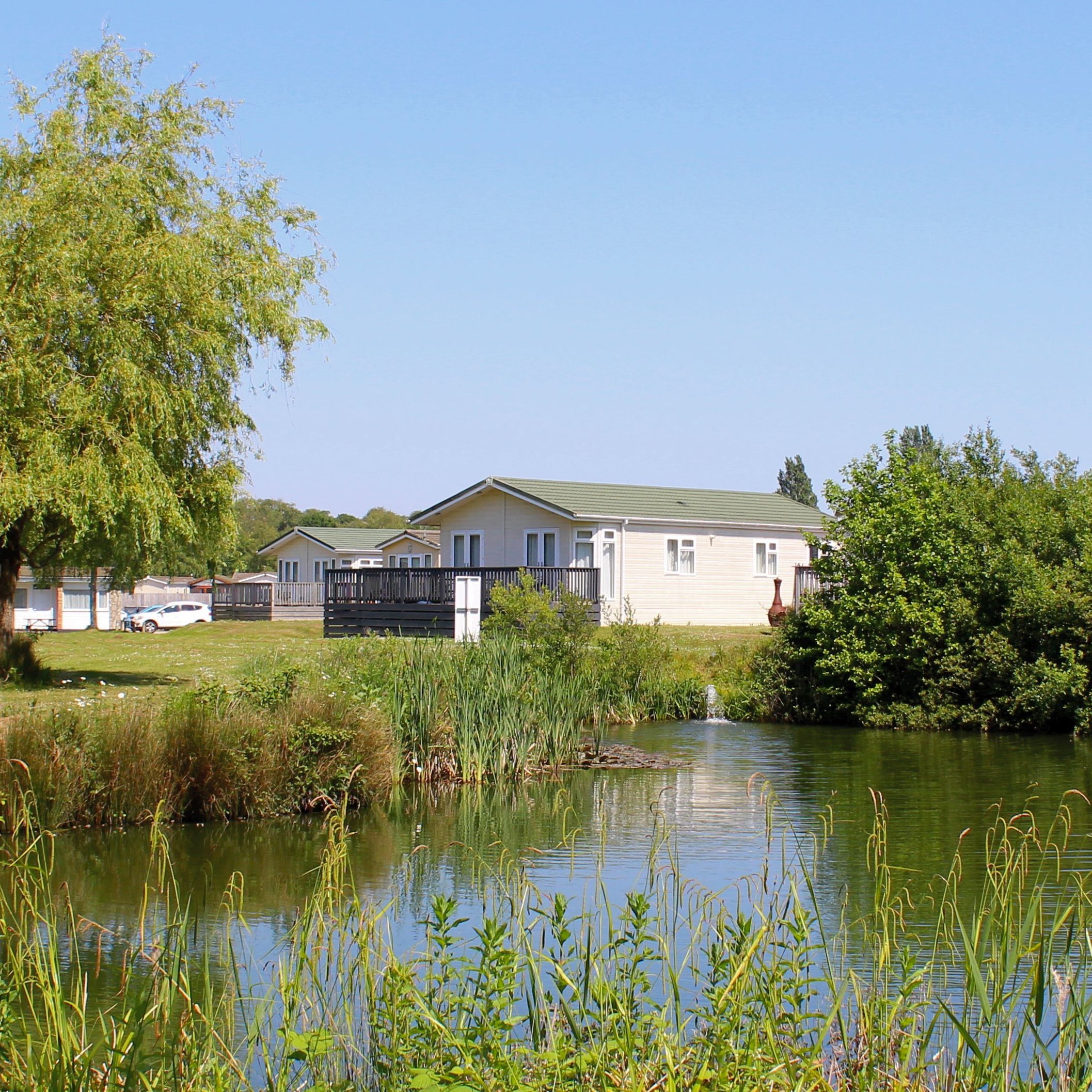 Holiday lodges overlooking a fishing lake at Hazelwood Holiday Park, Devon