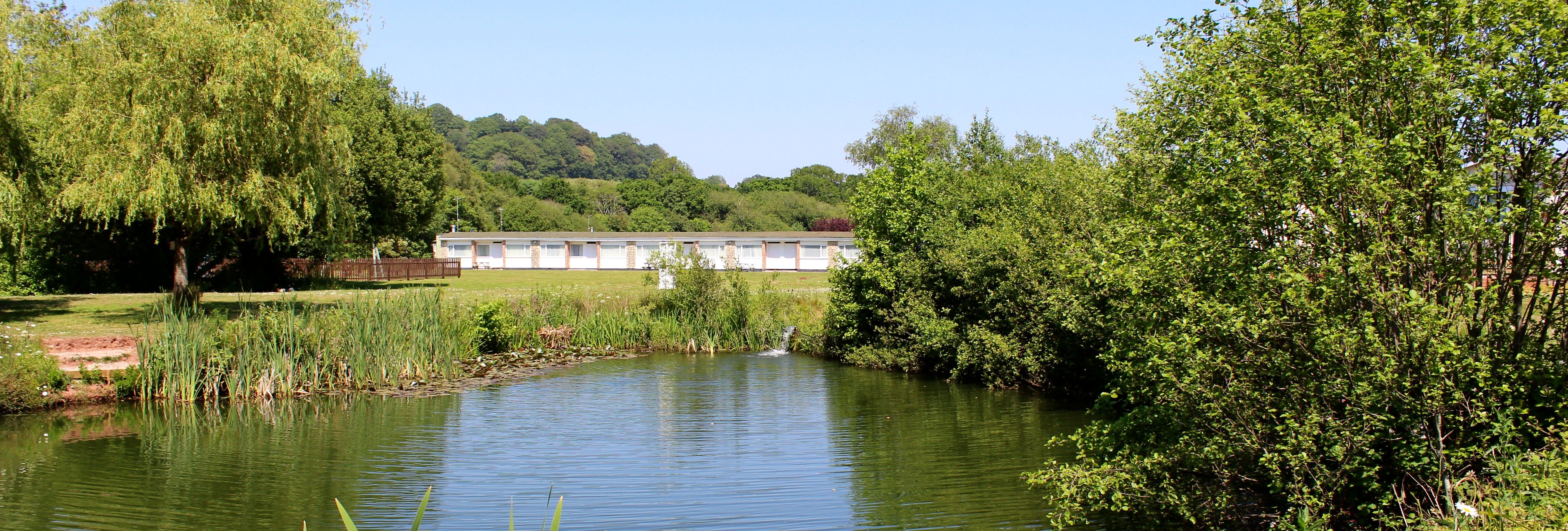 Ashwood Chalets viewed across Kingfisher Lake at Hazelwood Holiday Park