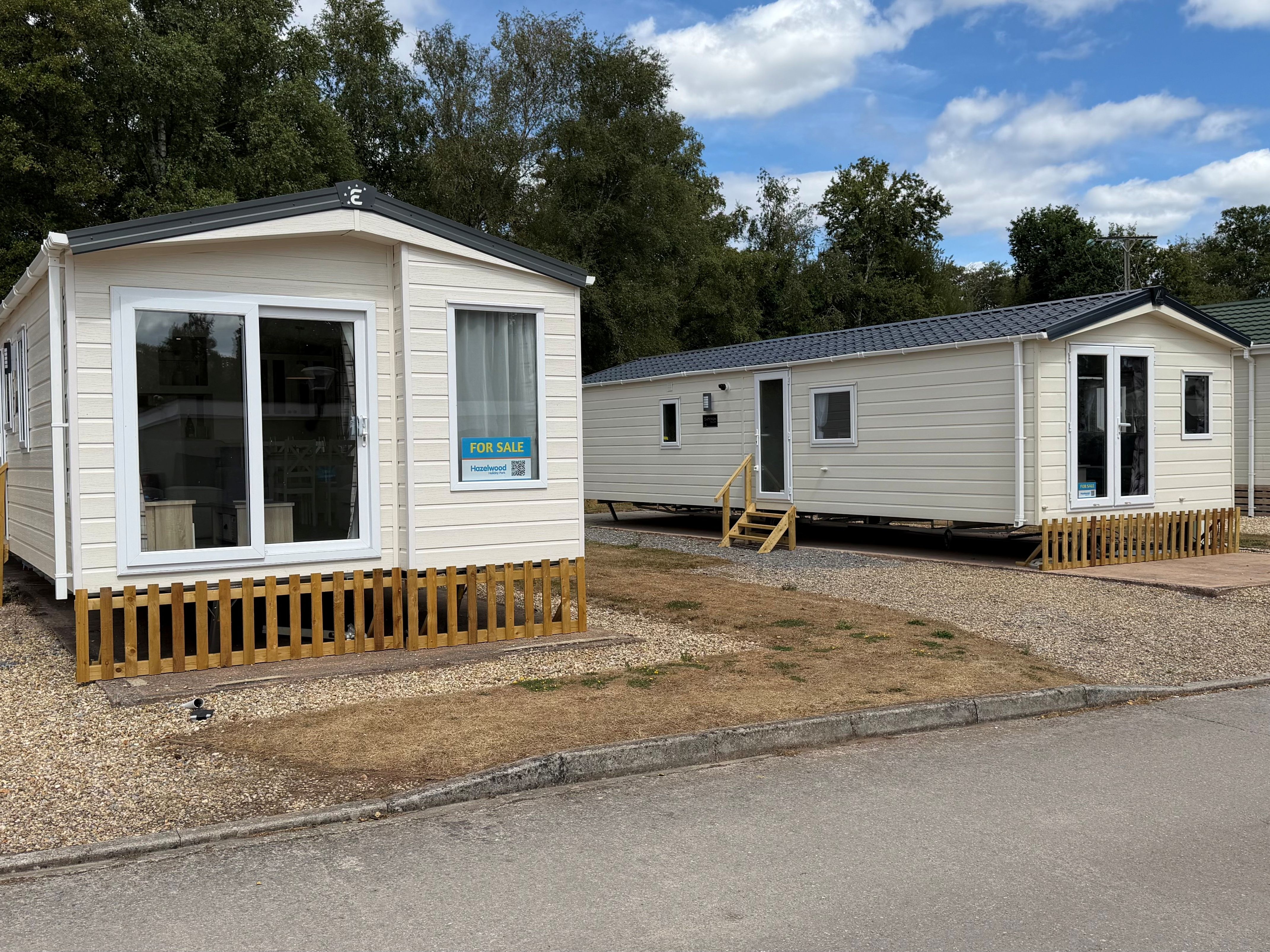 Two cream-coloured show homes with steps and small fences on Riverside