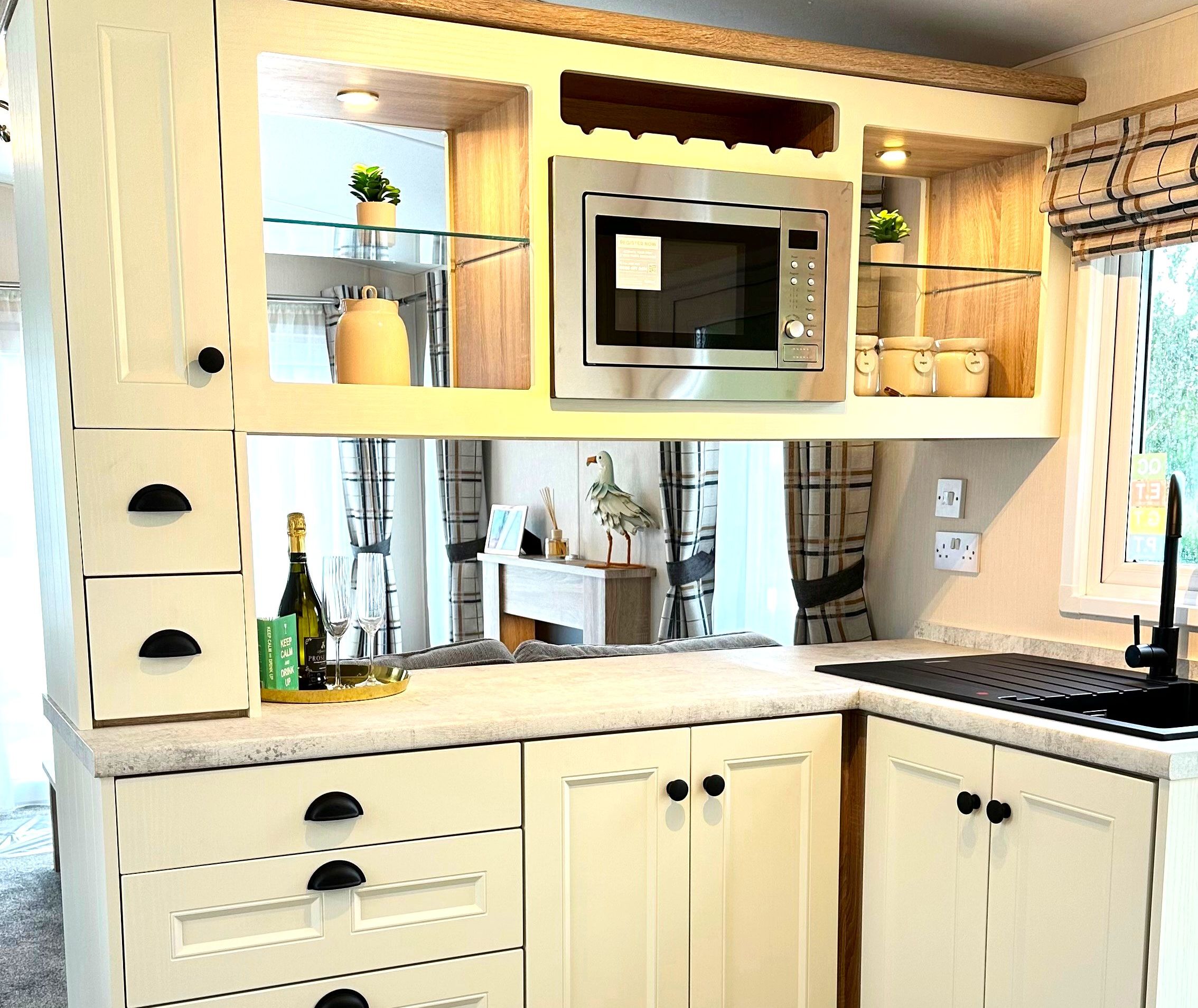 Cream shaker-style kitchen units with oak-effect worktop, built-in microwave and sink