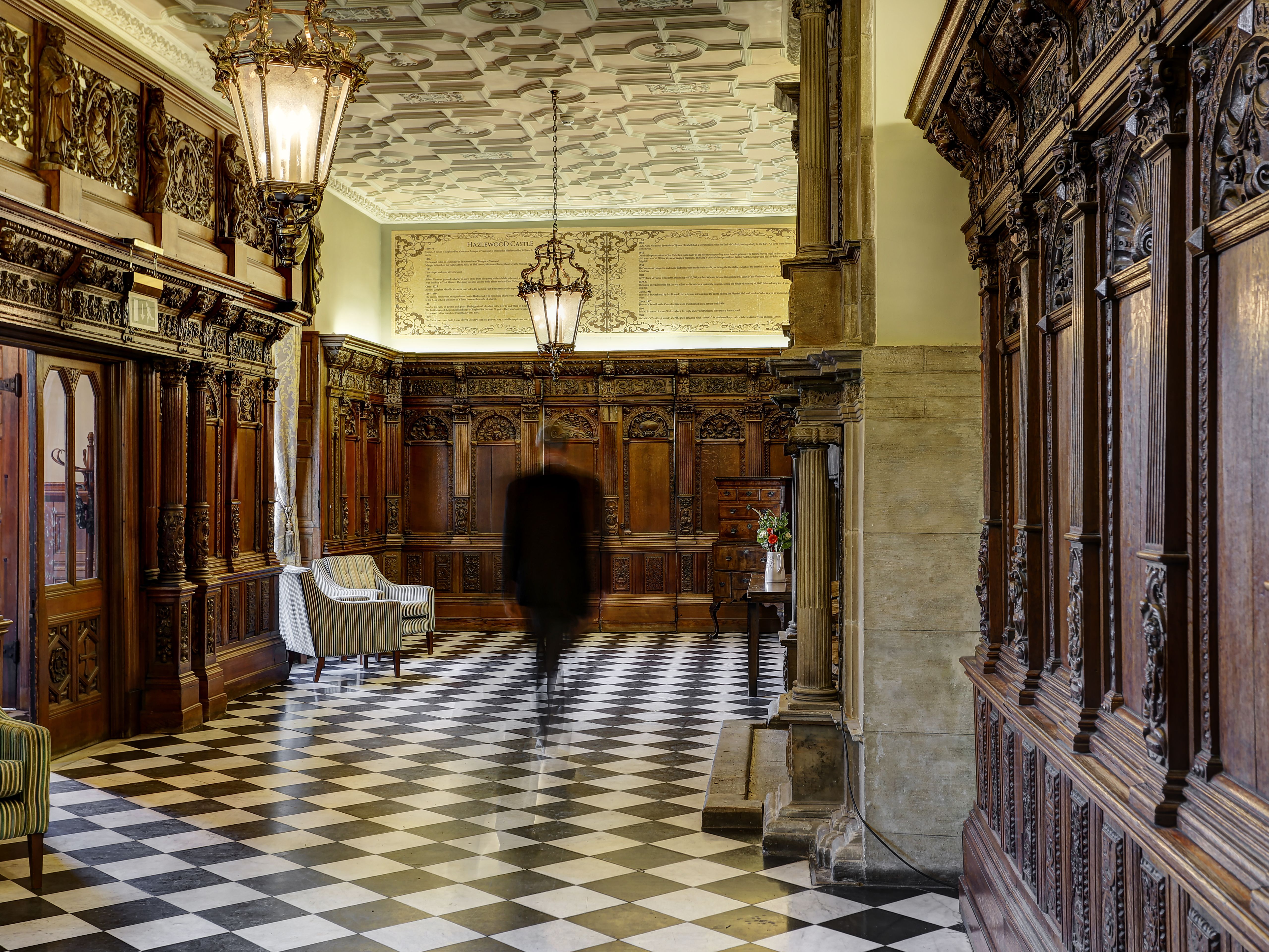 Elegant hotel interior with ornate wooden paneling and checkered floor
