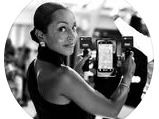 Person holding a smartphone and looking back at the camera in a monochrome photo