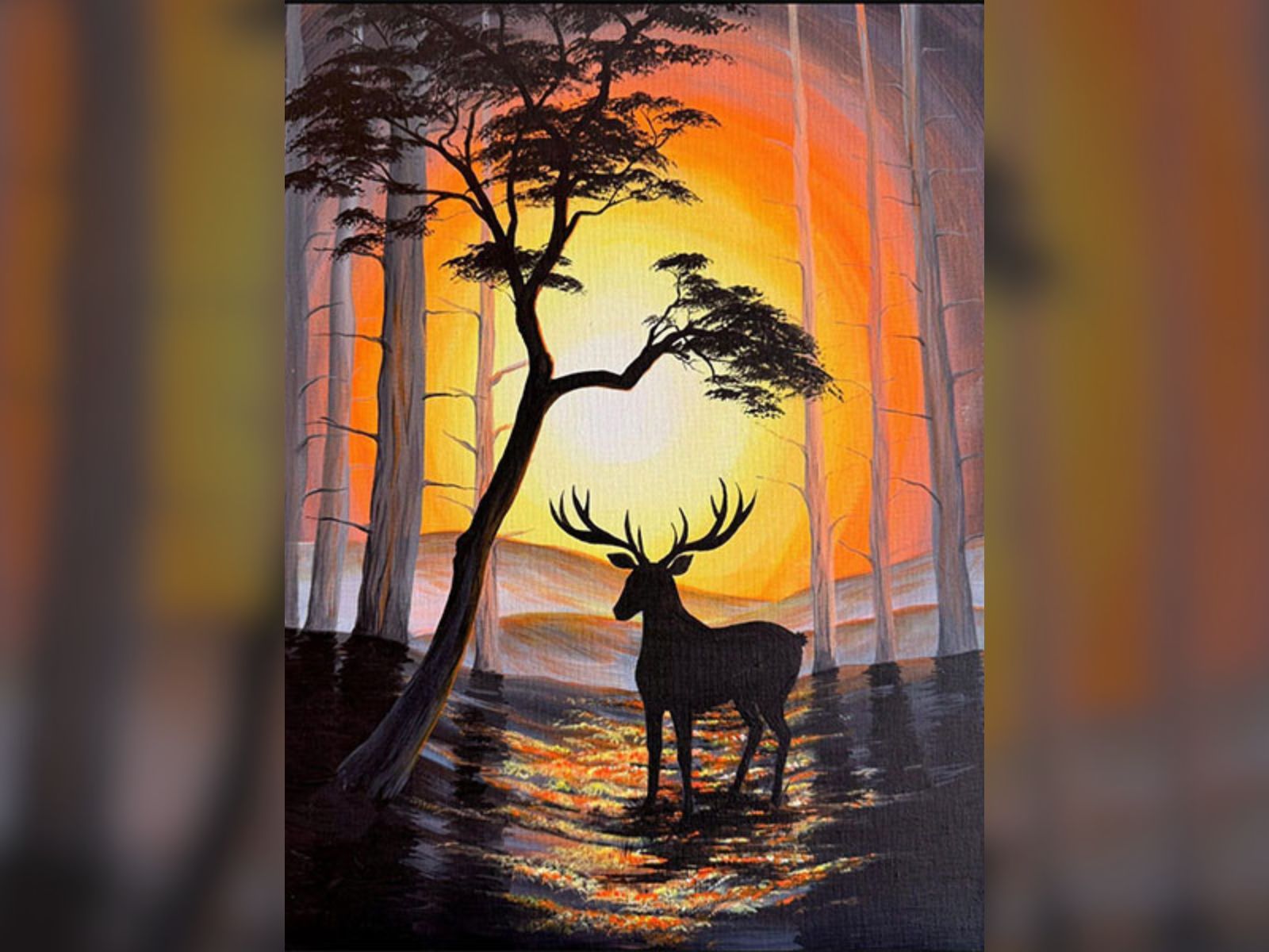 Silhouette of a deer and tree against a vivid sunset in a forest.