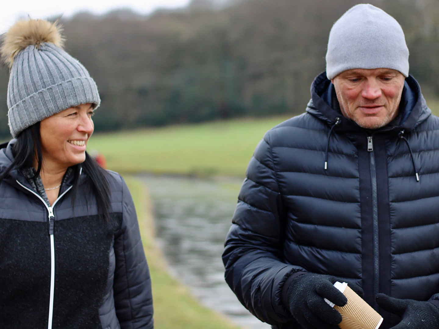 Couple walking outdoors in winter wearing warm jackets and hats