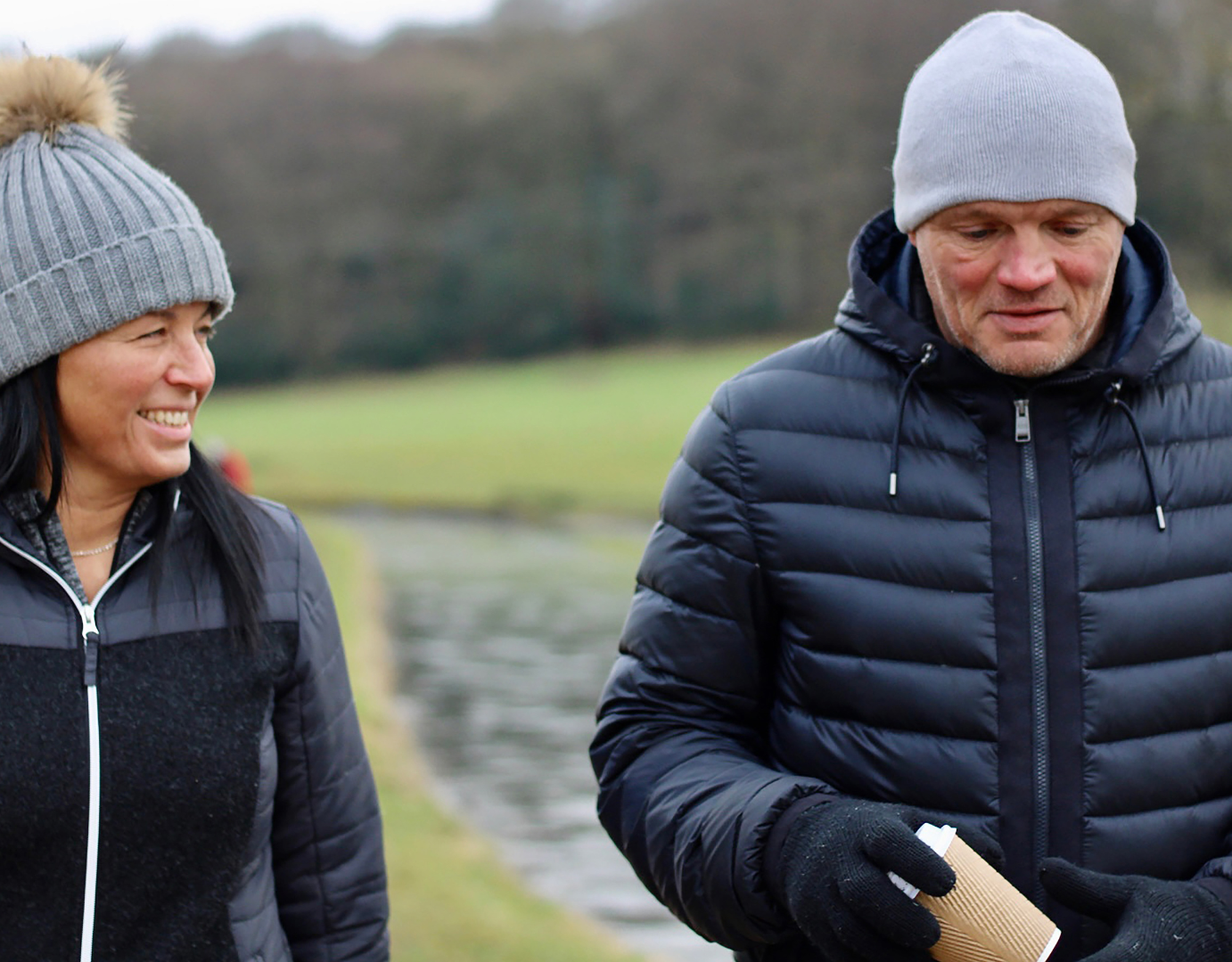 Couple walking outdoors in winter wearing warm jackets and hats